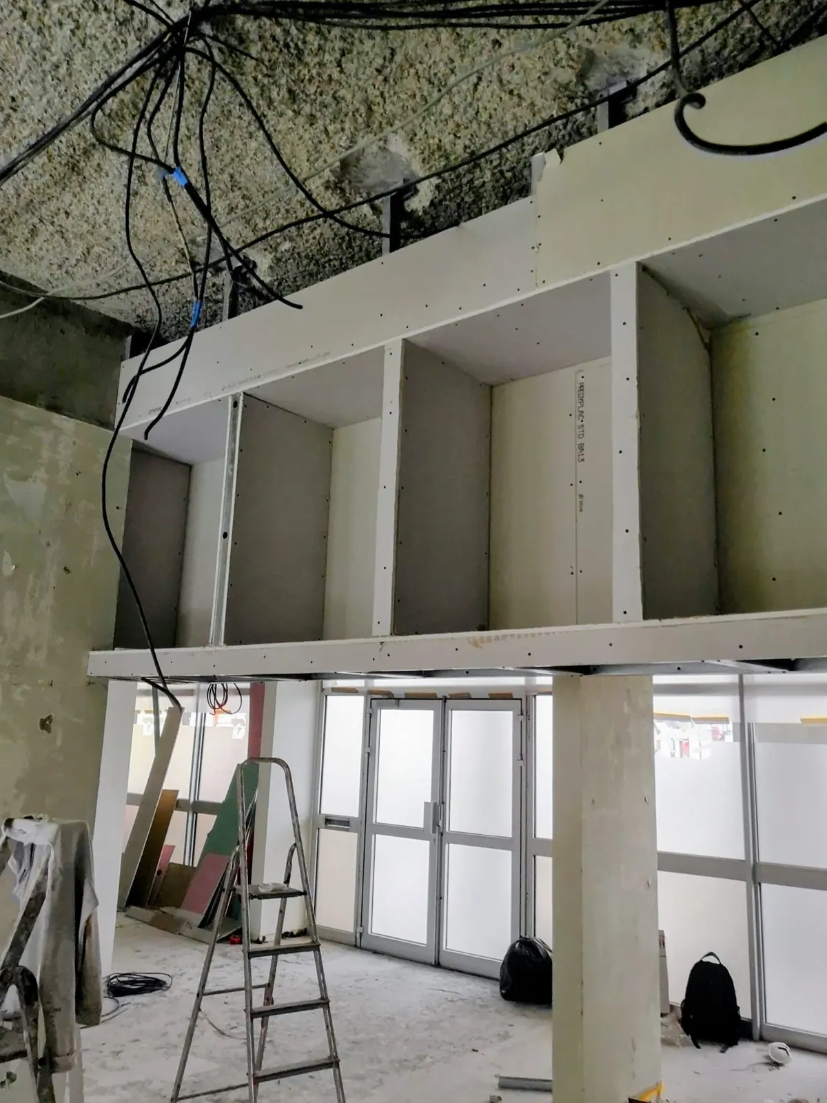 Caisson en plaques de plâtre sur ossature métallique en cours de pose dans un local en rénovation