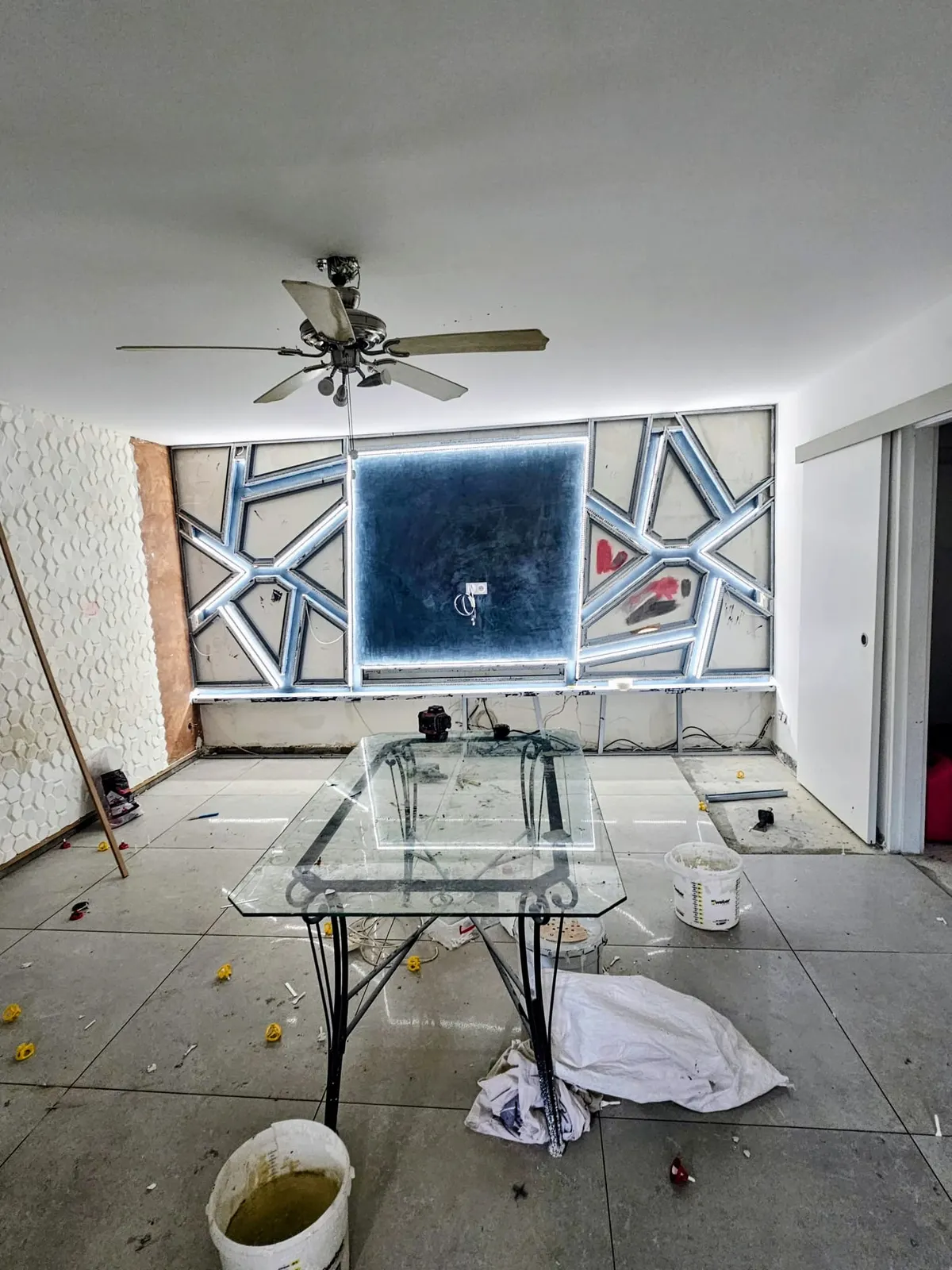Mur d'accent décoratif en plâtre rétroéclairé LED dans un séjour en rénovation