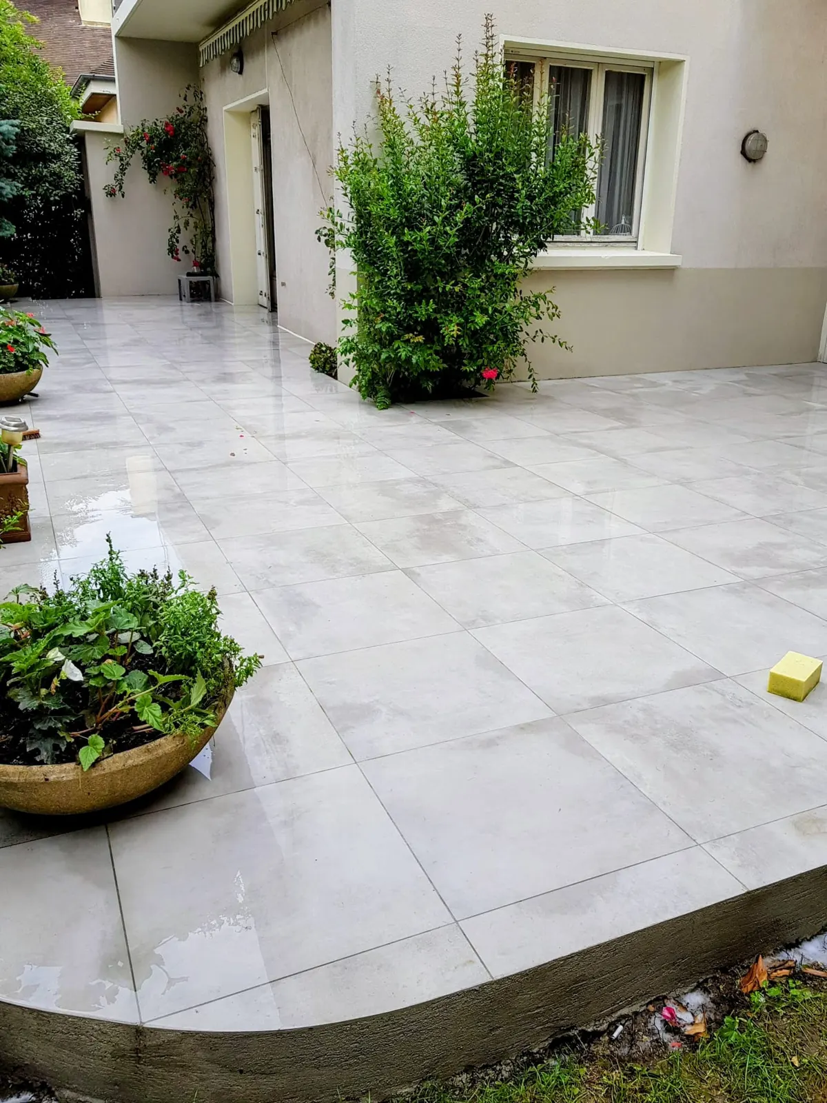 Terrasse extérieure en carrelage gris clair effet pierre après pose