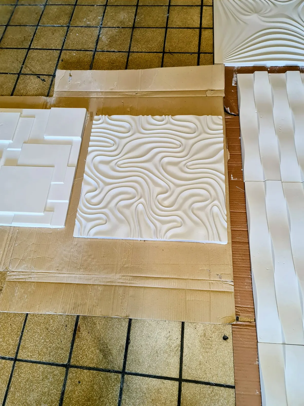 Panneaux décoratifs muraux 3D blancs présentés sur carrelage beige