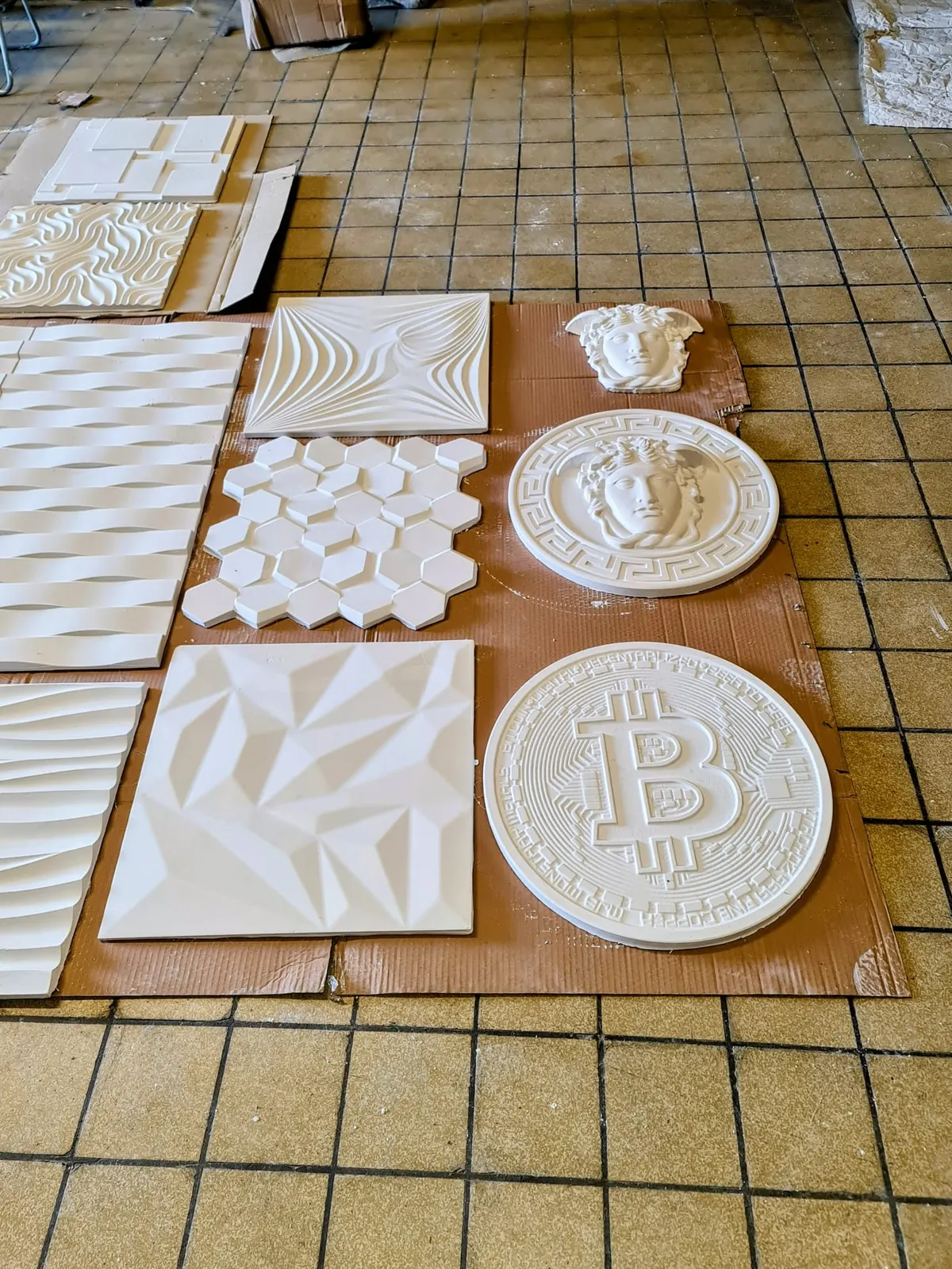 Assortiment de panneaux et médaillons décoratifs 3D blancs sur carrelage