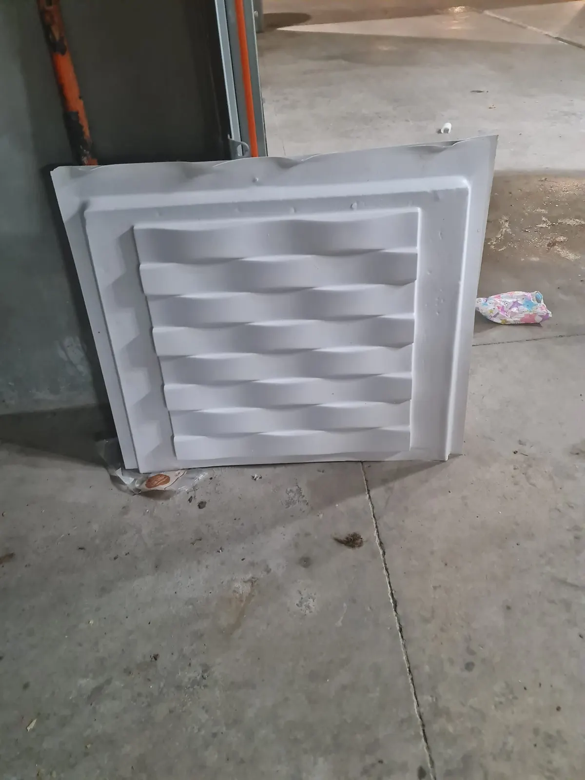 Panneau mural décoratif 3D blanc à motif ondulé posé au sol dans un local